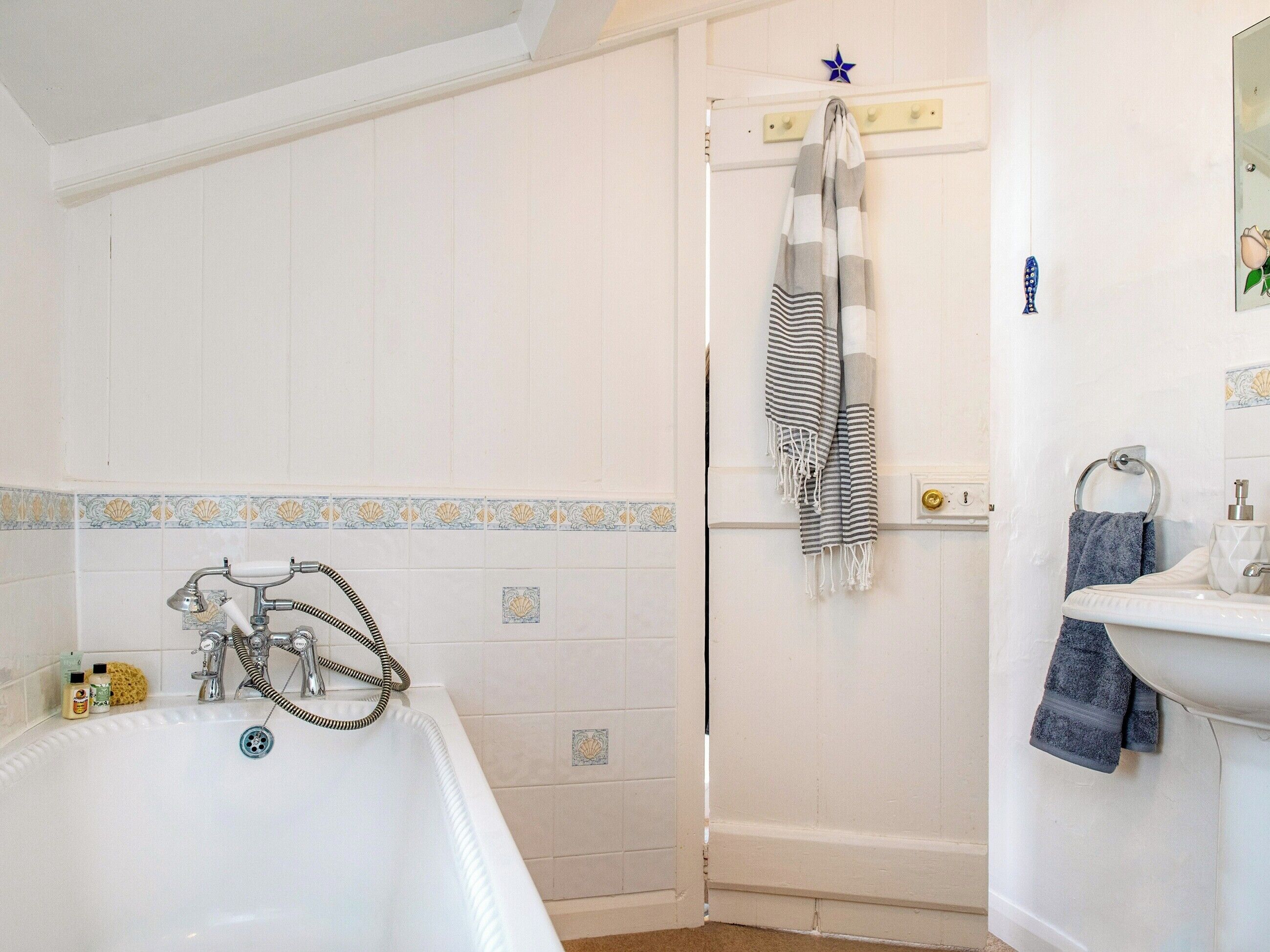 A bathroom with a bathtub, a shower, and a sink.