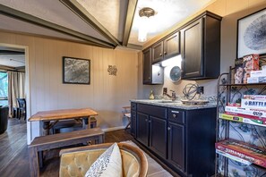 A kitchen with dark wooden cabinets, a granite countertop, and a dining area with a bench and table.