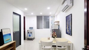 A modern kitchen with white cabinets, a built-in oven, and a microwave. - Services Apartment (Thành phố Hồ Chí Minh)