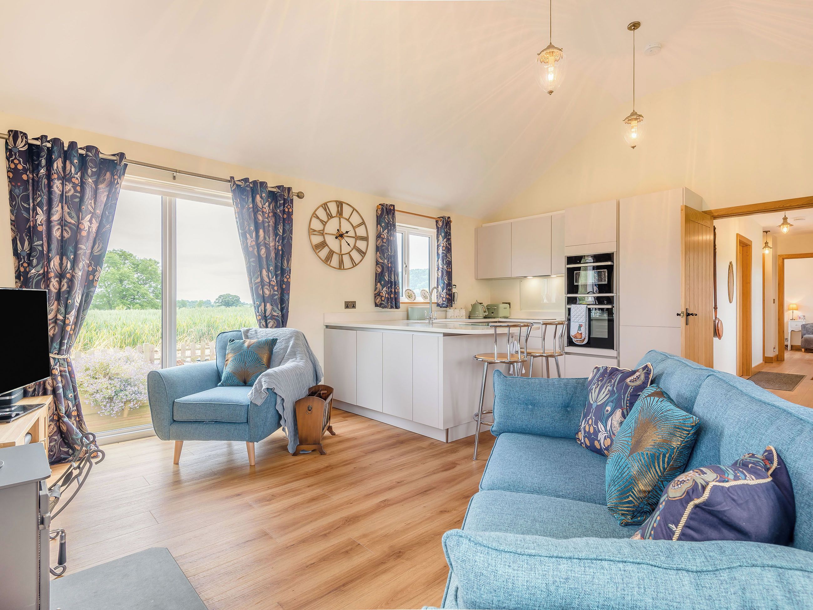 A spacious living area with a sofa, a dining table, and a kitchen area.