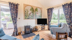 Ein Wohnzimmer mit Kamin, Fernseher und einer Couch.