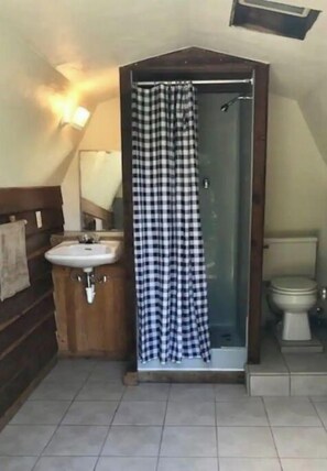 Chuveiro, toalhas de banho, sabonete, papel higiênico