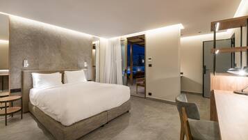 Una habitación de hotel moderna con una cama grande, un escritorio y un espejo.