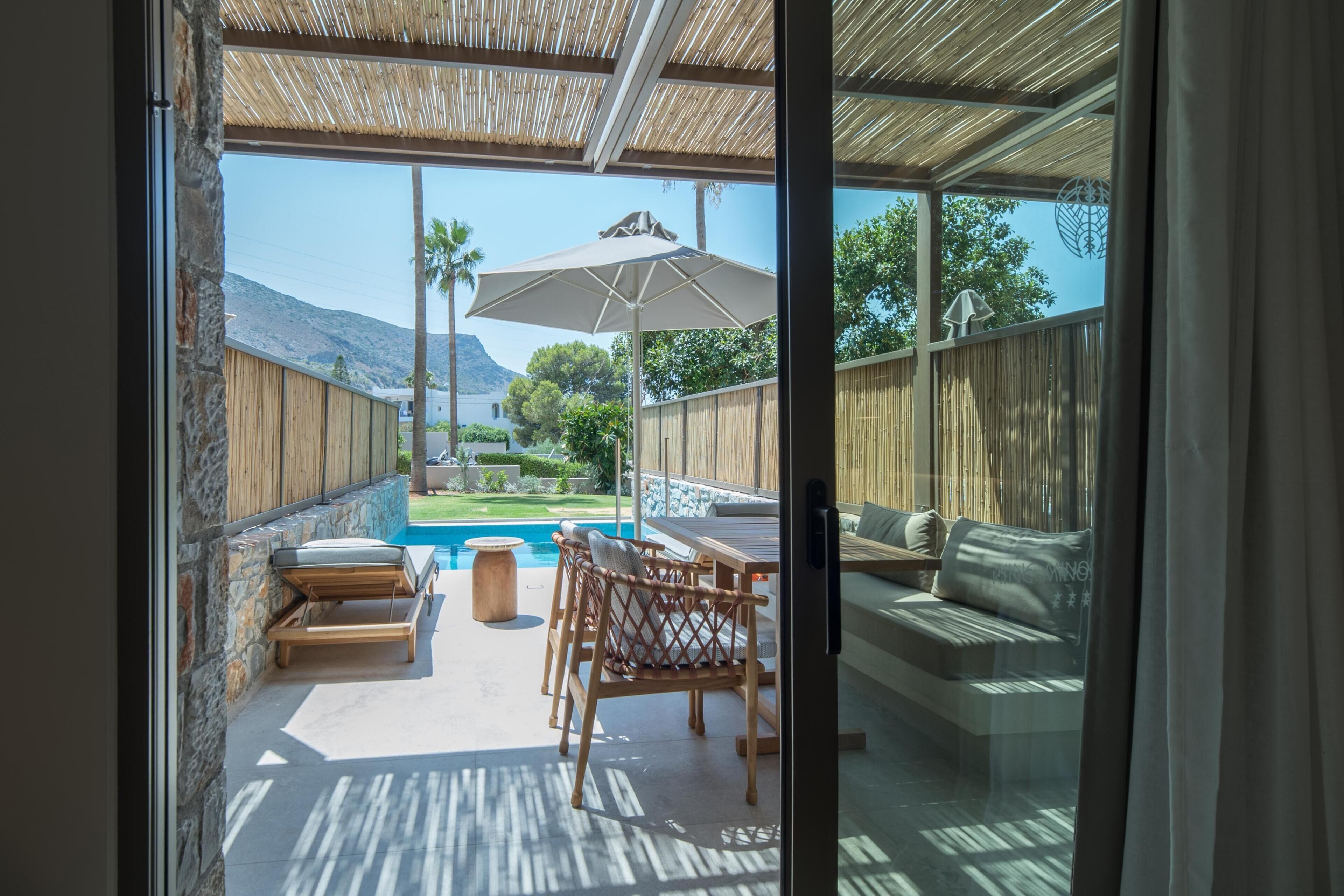 Un patio con piscina, mobiliario exterior y vistas del paisaje circundante.