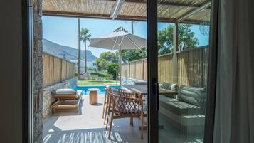 Un patio con piscina, mobiliario exterior y vistas del paisaje circundante.