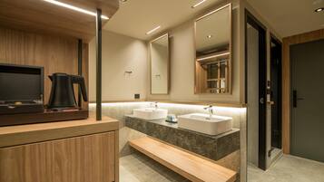 Un baño moderno con muebles de madera, un banco, dos lavamanos y un espejo grande.