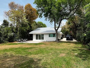 Enjoy a peaceful retreat in this serene house surrounded by lush greenery and a patio.