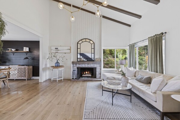 Cozy living space with a fireplace, comfortable sofa, and dining area.
