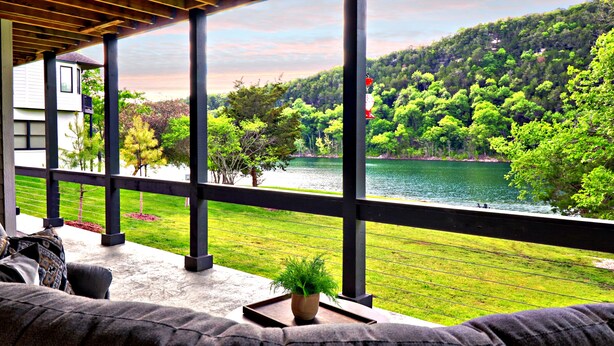 Ein überdachter Sitzbereich mit Blick auf einen See und einen Wald.