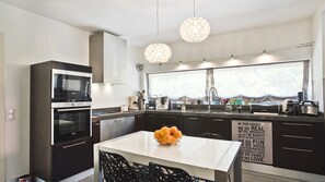 Enjoy cooking in this well-equipped kitchen with a central island, oven, and microwave.