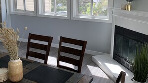 A dining area with a table, chairs, and a fireplace.