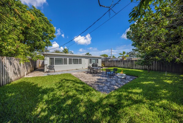 A backyard with a patio, a grill, and a small pool. - Newly Remodeled Home with Spacious Backyard! (Fort Lauderdale)