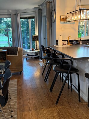 Een moderne keuken met een bar, houten vloeren en uitzicht op het landschap.