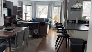 A spacious living area with a dining table, chairs, a sofa, and a kitchen area with a counter and sink. - A  peaceful country retreat a block away from the beach,with beautiful sunsets.  (Dunnottar)