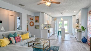 A modern living room with a sofa, coffee table, and a ceiling fan. - Wynfield Place (St. Augustine)