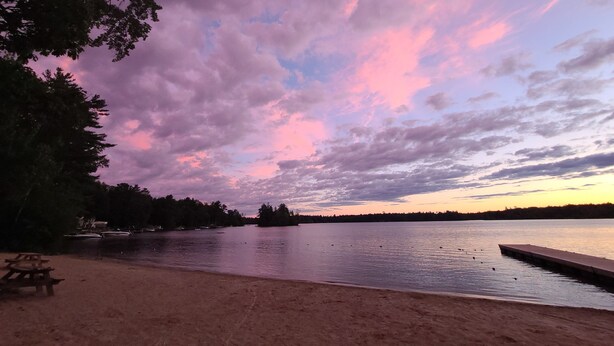 A lakeside view with a wooden dock and picnic tables. - Cute romantic studio  (Moultonborough)