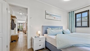 Ein Schlafzimmer mit einem Bett, einem Nachttisch und einem Bild an der Wand.