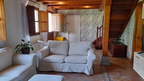 A cozy living room with a sofa, a small table, and a potted plant. - Gestiona2R. House on the coast of Llanes for 8 people (Llanes)