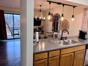 Una cocina con una isla grande, electrodomésticos de acero inoxidable e iluminación colgante.