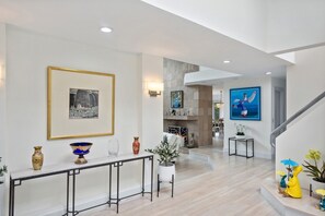 Cozy living area with a fireplace and staircase leading to an upper level.