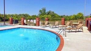 A swimming pool with lounge chairs and a brick wall. - 8 min to Dollywood- Close to parkway River and Mountain Views 2BR/2BA Sleeps 6  (Sevierville)
