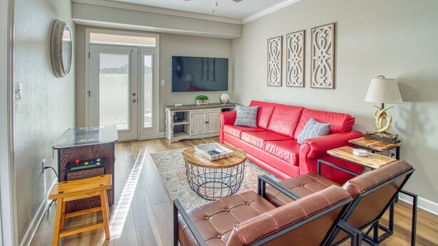 A living room with a red sofa, a coffee table, a TV, and a ceiling fan. - 8 min to Dollywood- Close to parkway River and Mountain Views 2BR/2BA Sleeps 6  (Sevierville)