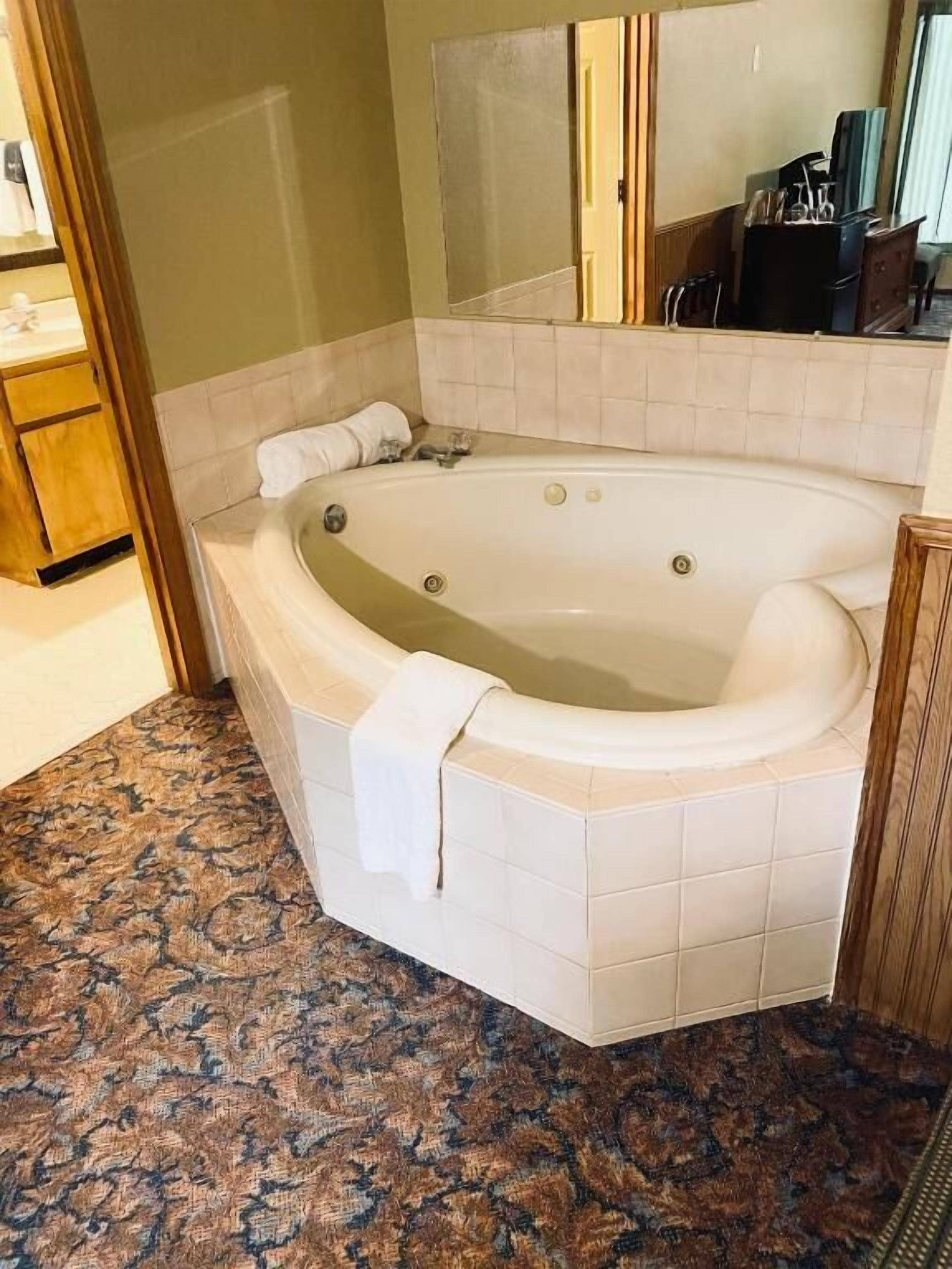Une salle de bain avec une baignoire sur pieds, un meuble en bois et un miroir au-dessus de la baignoire.