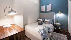A bedroom with a bed, bedside lamps, a small table, and two framed artworks on the wall. - Downtown Mich Ave #10 | gym+rooftop (Chicago)