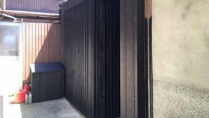 A garage with a wooden door, a window, and a bicycle rack on the wall.