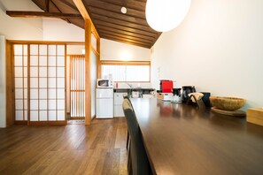 A traditional Japanese-style kitchen with wooden flooring, a dining table, and a sliding door. - Ikebukuro Nigo - Tokyo architectural small villa (Tokyo)