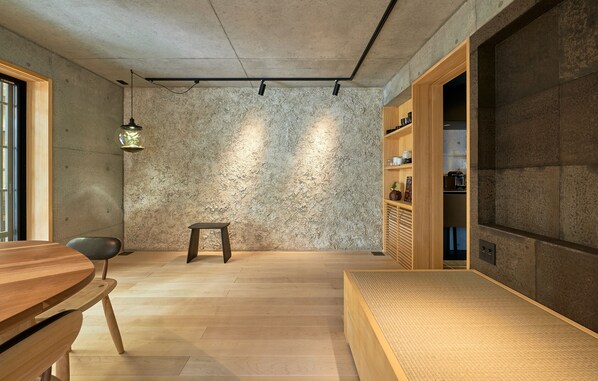 Un interior moderno con una pared de textura de hormigón, muebles de madera y estanterías empotradas.