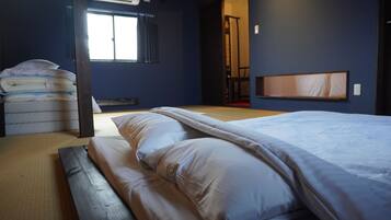 A room with a bed, pillows, a mattress, a window, and a door.