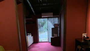 Een traditionele Japanse kamer met tatami vloermatten, een lage houten tafel en een groene bank.