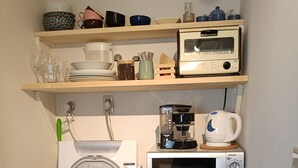 Une cuisine compacte équipée d’un lave-linge, d’un four à micro-ondes et d’un réfrigérateur.