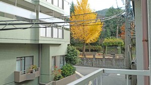 A multi-story residential building with balconies and a street view.