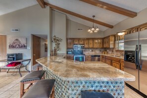 Enjoy cooking in this well-equipped kitchen with a large island, appliances, and ample cabinetry.