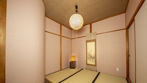 Et traditionelt japansk rum med tatamimåtter, en shoji skydedør og en hængende papirlampe.