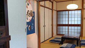 A traditional Japanese room with tatami flooring, sliding doors, and a low table with cushions. - Gion Rokudo - Comfortable house in Gion (Kyoto)