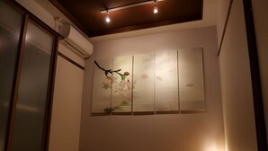 A tatami mat room with a shoji screen, a wall-mounted air conditioner, and a traditional Japanese painting. - Sakura Aburaya - Perfect traditional & comfortable house (Takayama)