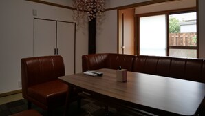 A conference room with a long table, leather chairs, and a decorative floral arrangement. - Sakura Aburaya - Perfect traditional & comfortable house (Takayama)