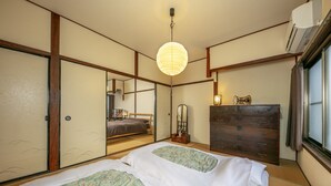 Een traditionele Japanse kamer met tatami vloeren, twee tatami matten, een houten dressoir, een spiegel en een hangende lantaarn van papier.