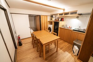 A compact kitchen with wooden cabinets, a built-in microwave, and a small sink.