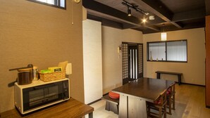 Uma cozinha compacta com micro-ondas, uma mesa de madeira e um banco.
