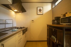 A compact kitchen with a stove, microwave, and coffee maker. - Gojo Machiya - Traditional & comfortable Kyoto Machiya (Kyoto)
