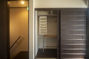 Ein Hotelzimmer mit Schiebetür zu einem Kleiderschrank, einem Bett und einer kleinen Sitzecke.