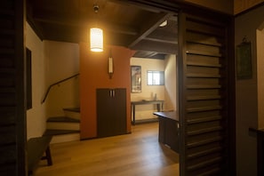 Un escalier menant à une pièce dotée d’un plancher en bois, d’un bureau et d’une fenêtre.