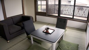 Una habitación con sofá, una mesita y vistas al exterior a través de una ventana.