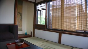 Una habitación japonesa tradicional con suelo de tatami, una mesa baja con un cuenco y un shoji corredero.