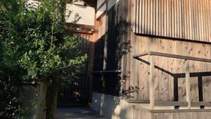 Una casa tradicional de madera con una escalera de madera que lleva a la entrada.