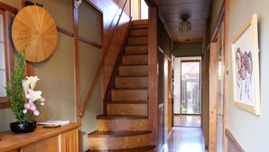 Una escalera de madera con diseño curvo que conduce a una habitación con piso de madera y vistas al exterior.